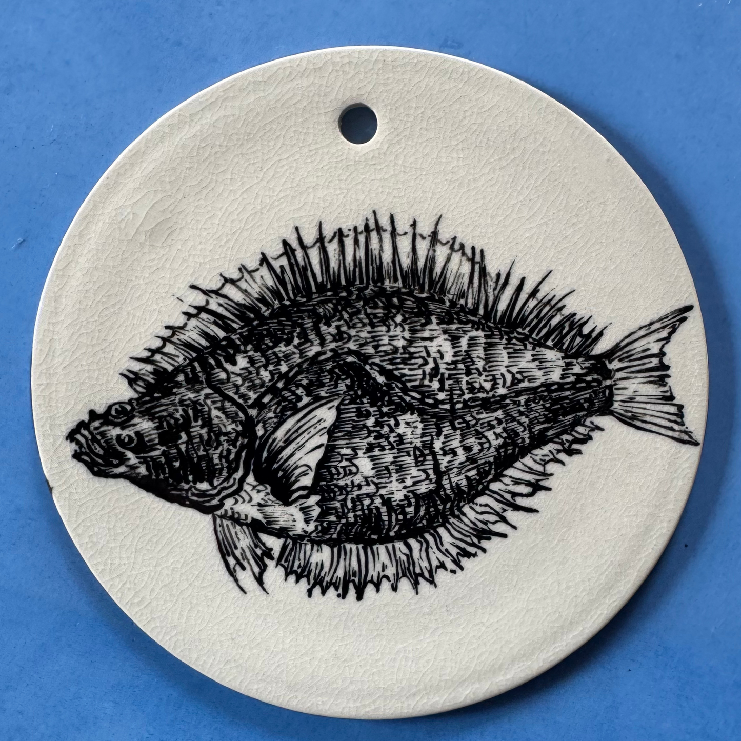 Top-down weergave van de handgeschilderde zwarte dorade-vis op de 16 cm keramische wand-/serveerschaal.