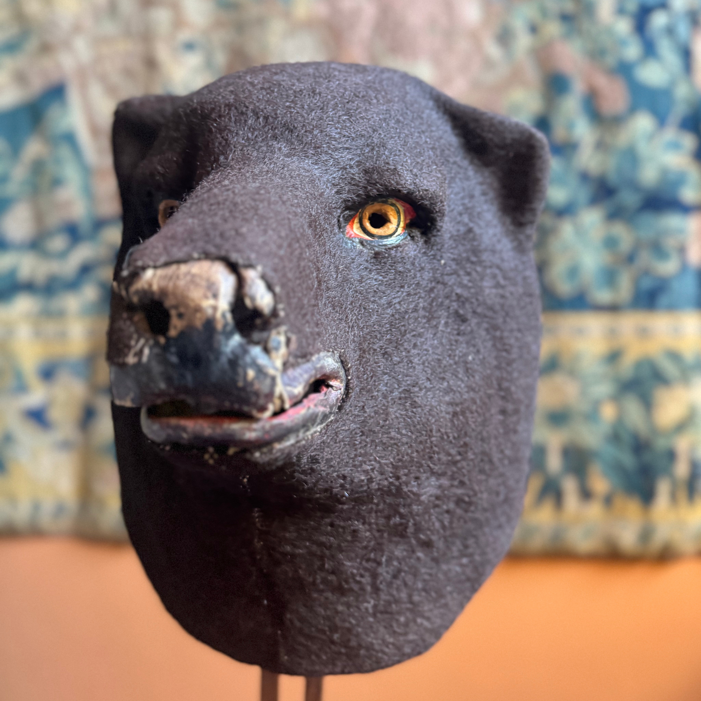 Front view of papier-mâché bear headpiece covered in felt with hand-painted eyes