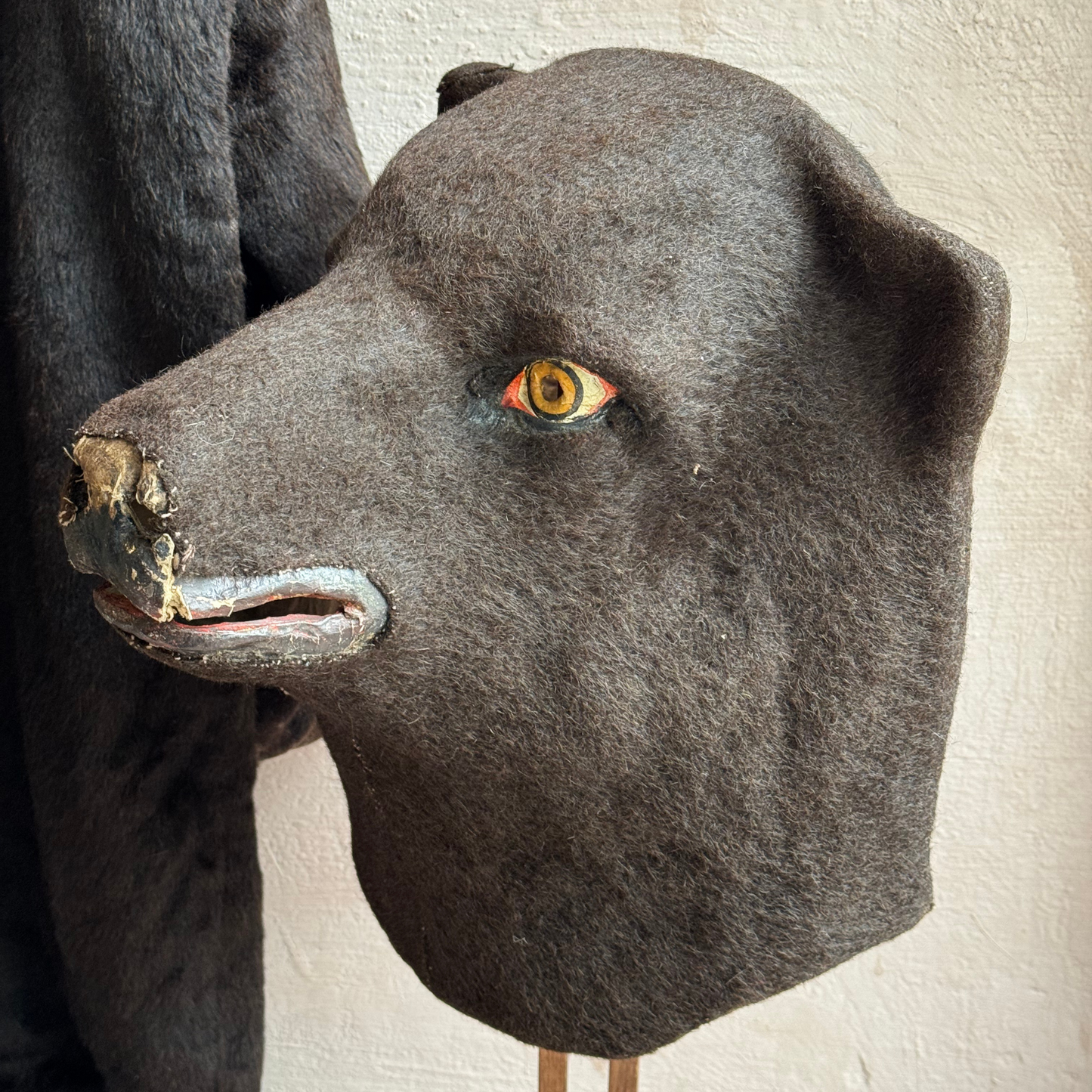 Side profile of felt-covered bear headpiece, highlighting fixed jaw and ear shape
