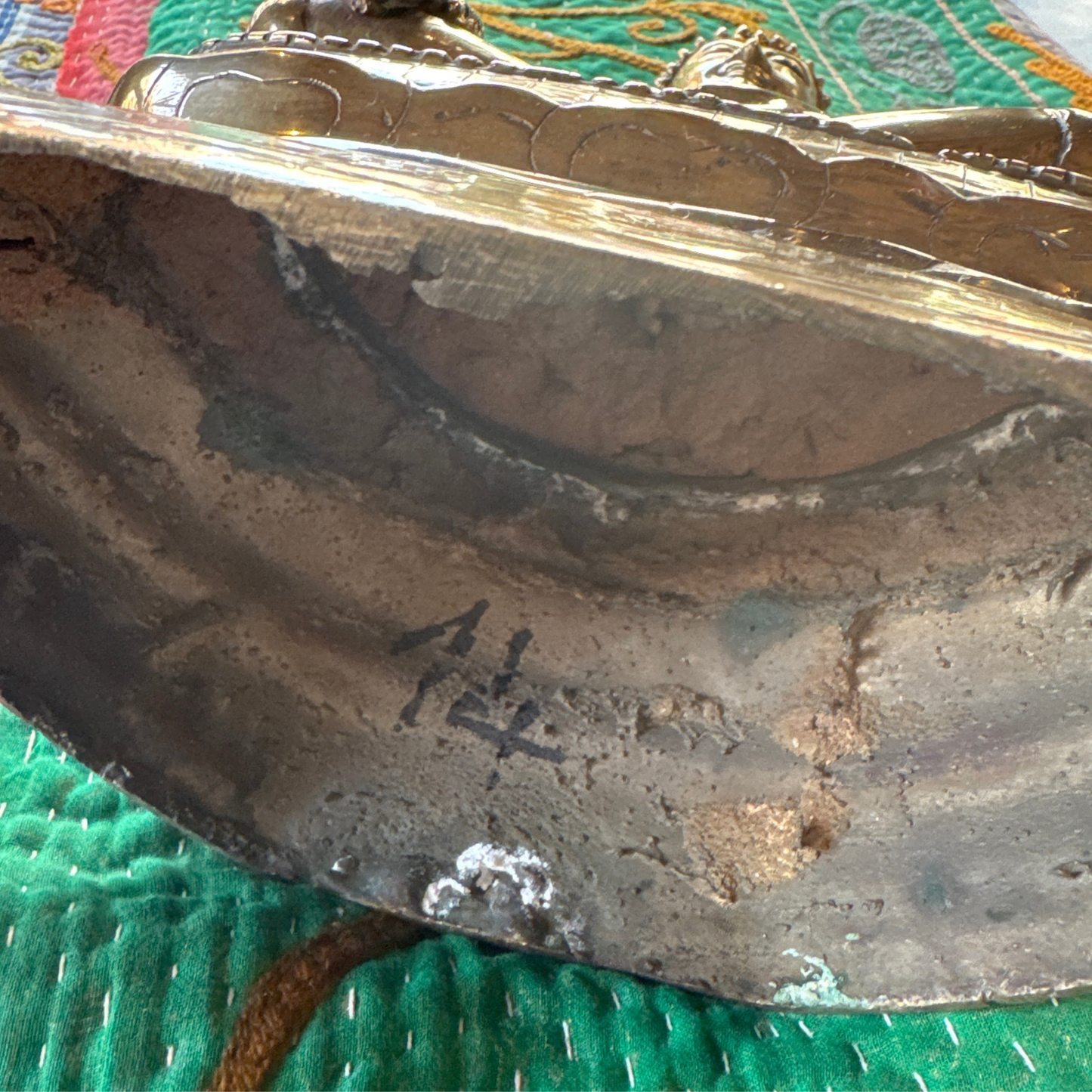 Detail of underside showing maker’s mark and casting residue in the base cavity