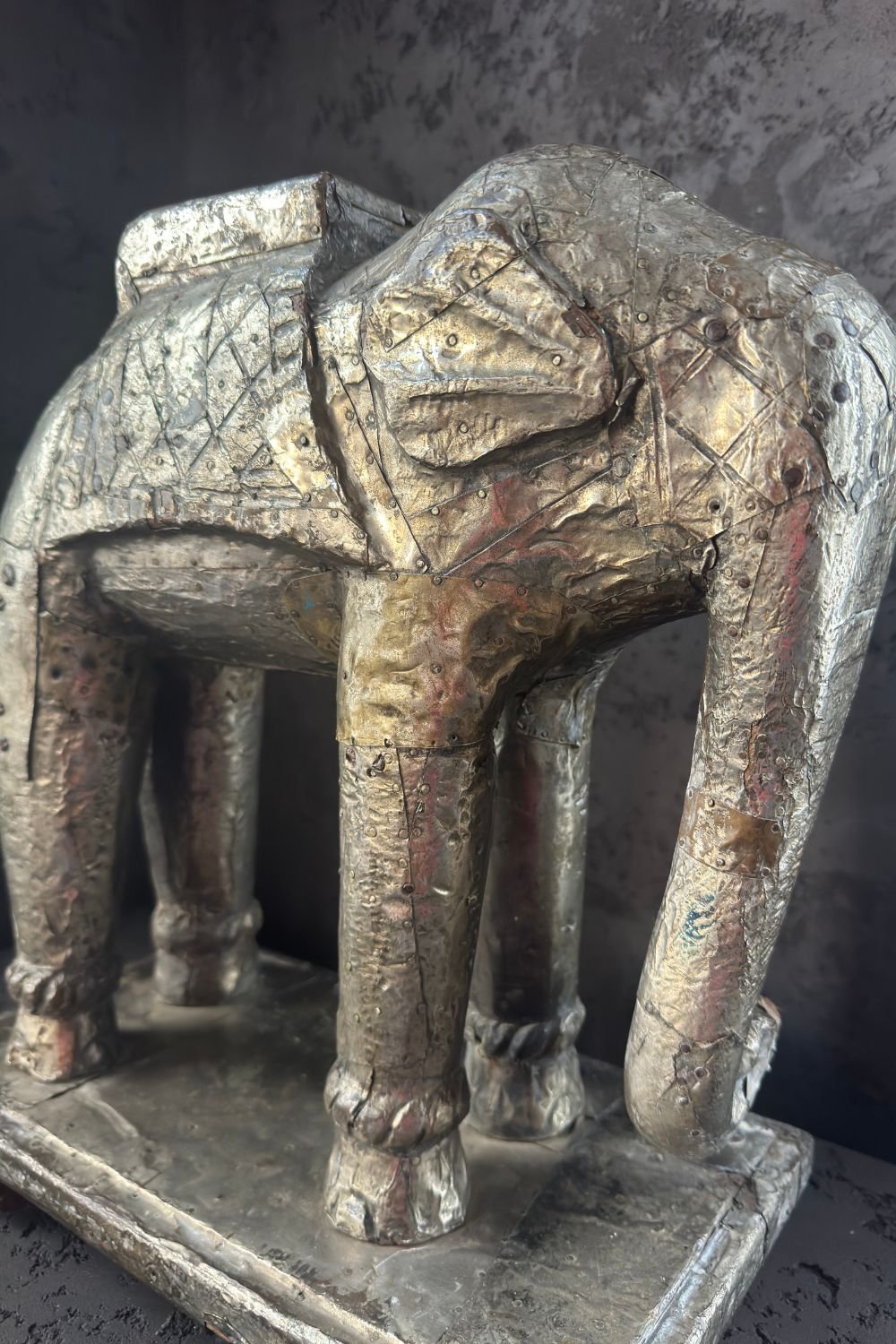 Angled view highlighting the elephant sculpture’s front leg details and oxidized metal texture.