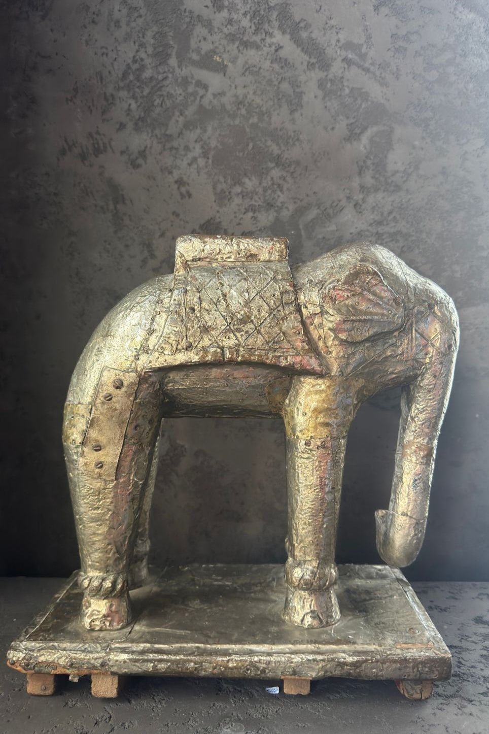 Side profile of the wooden elephant statue with visible surface patina and faded pigment traces.