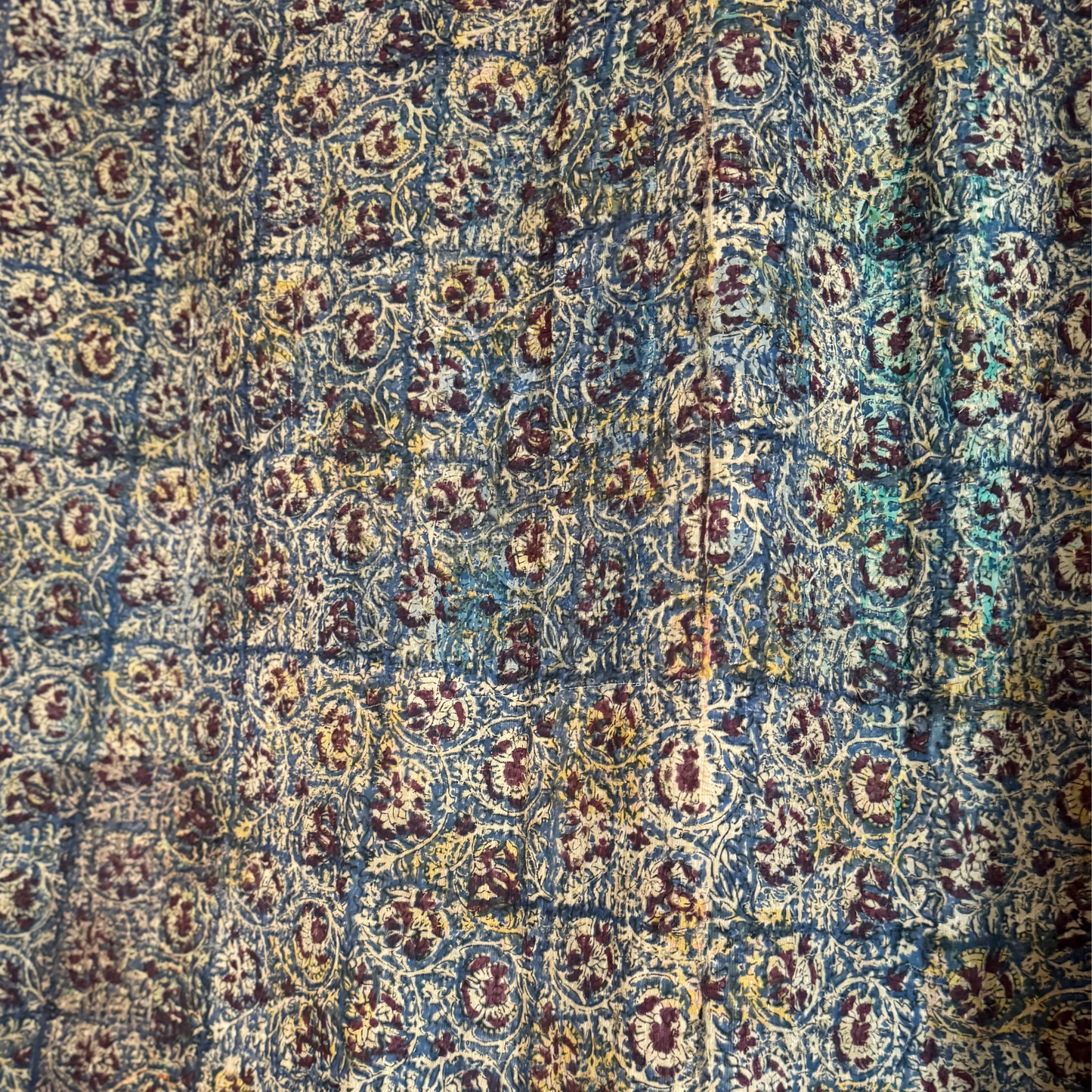 Backside of kantha showing detailed indigo block print with floral and vine pattern