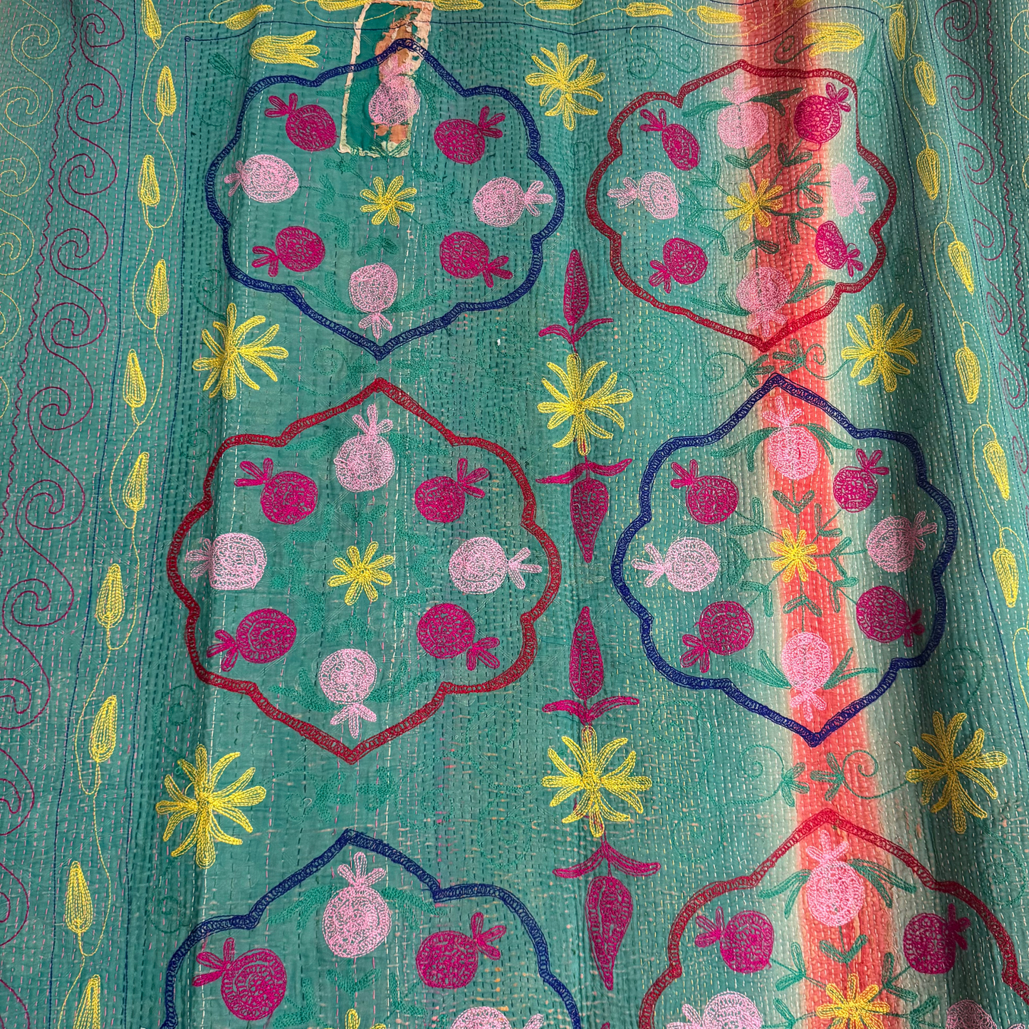 Back-side close-up of mint-green vine embroidery on reversible Kantha blanket
