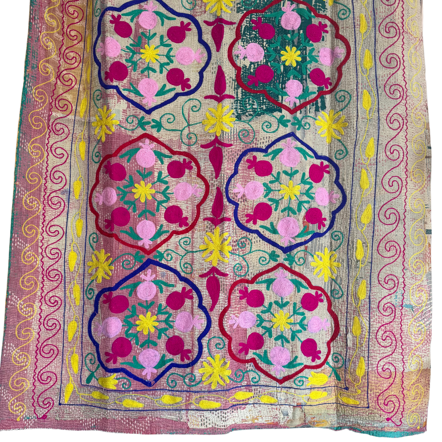 Close-up of fuchsia-pink pomegranate medallion embroidery on teal cotton Kantha throw