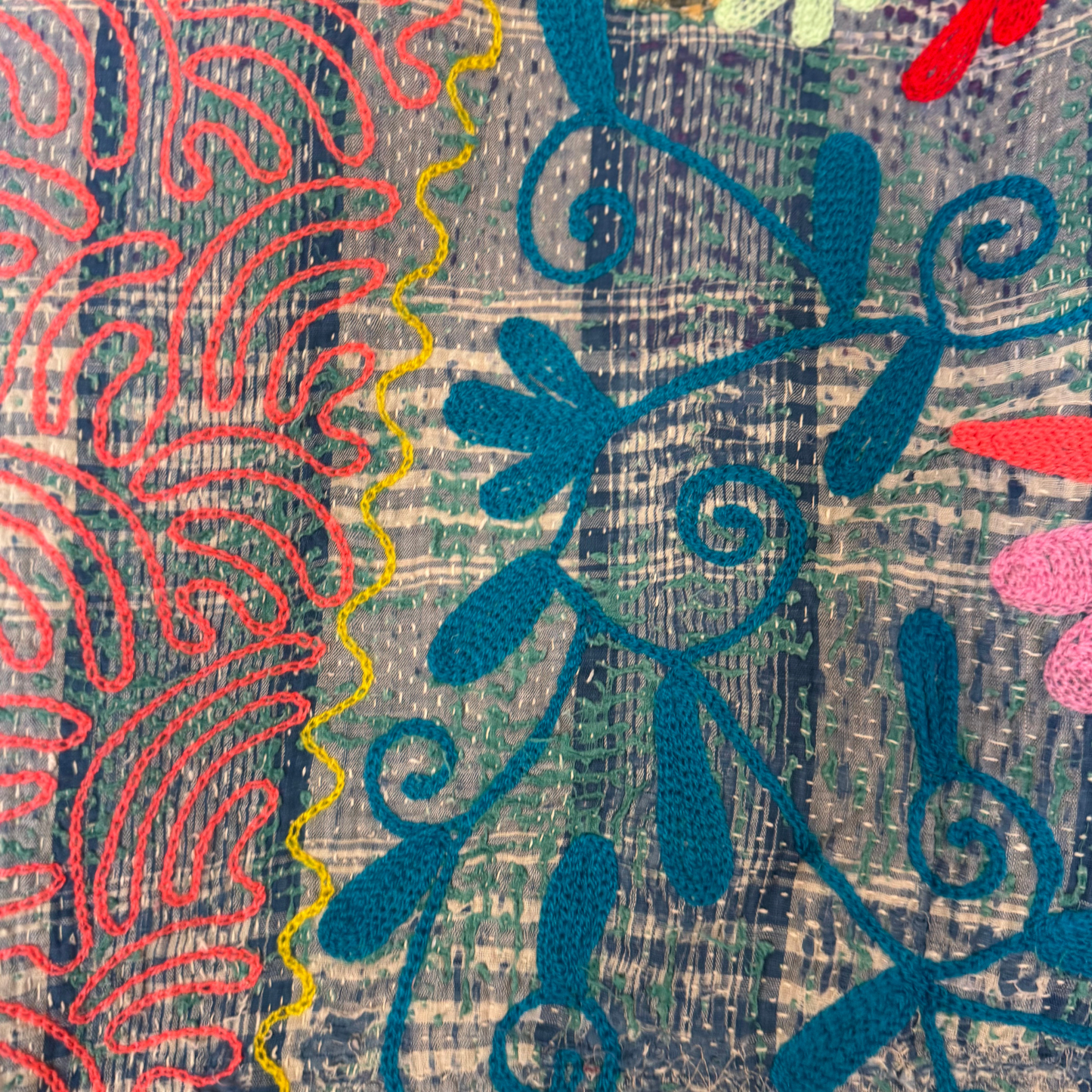 Close-up of coral-pink tulip embroidery and teal vine stitchwork on cotton Kantha quilt throw