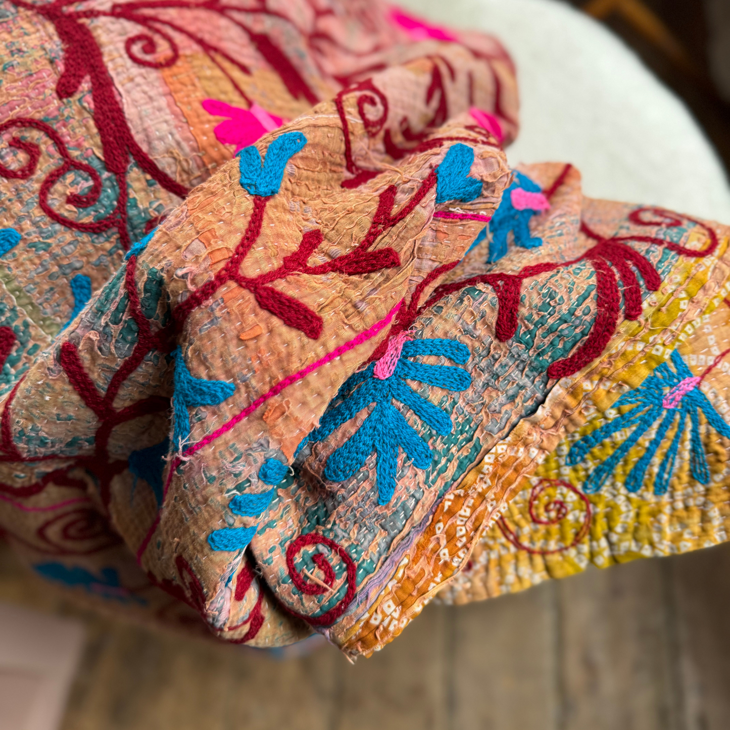 Close view of textured heavy cotton kantha with vibrant stitched motifs and visible hand quilting