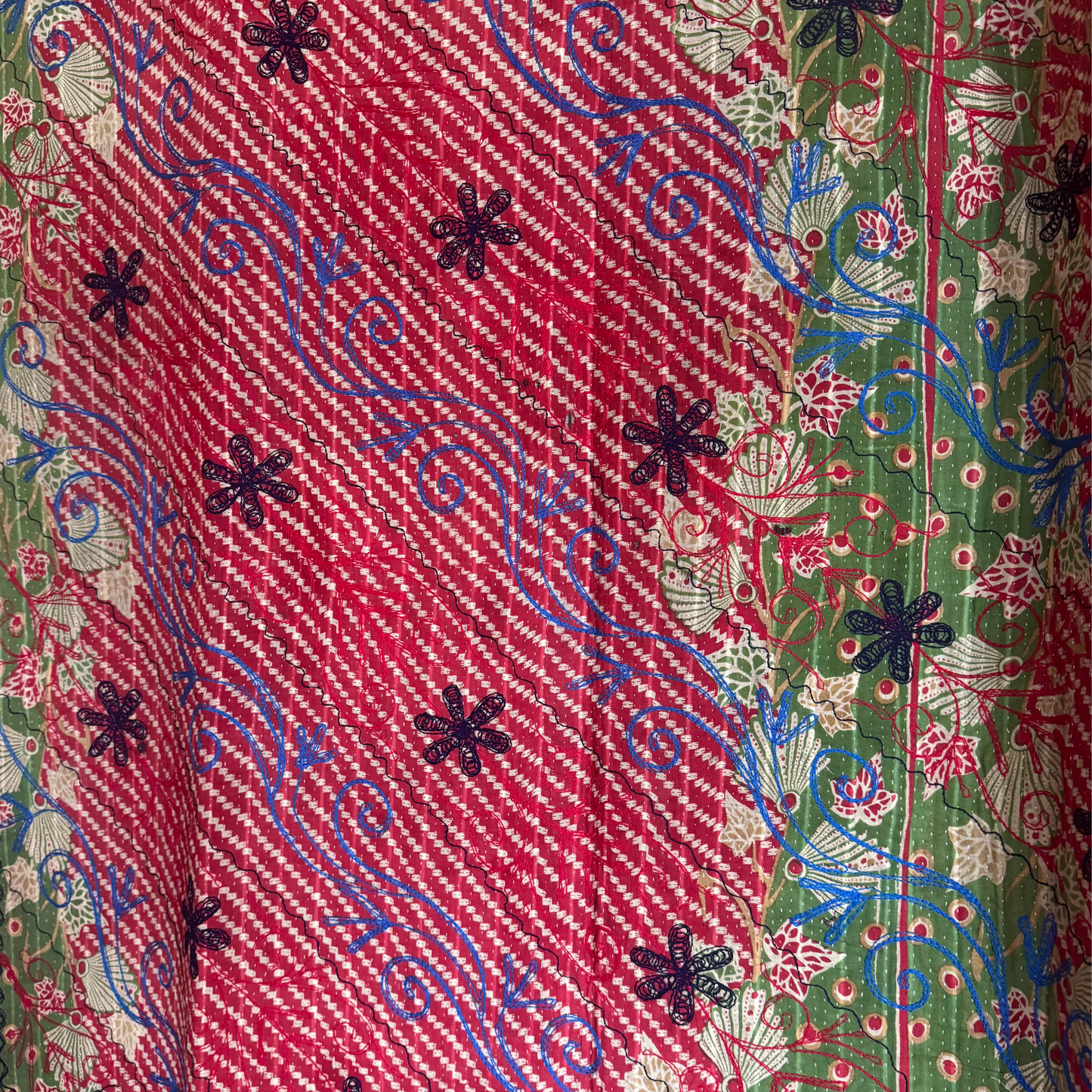 Macro shot of lightweight cotton base with dense running-stitch texture and vibrant threads