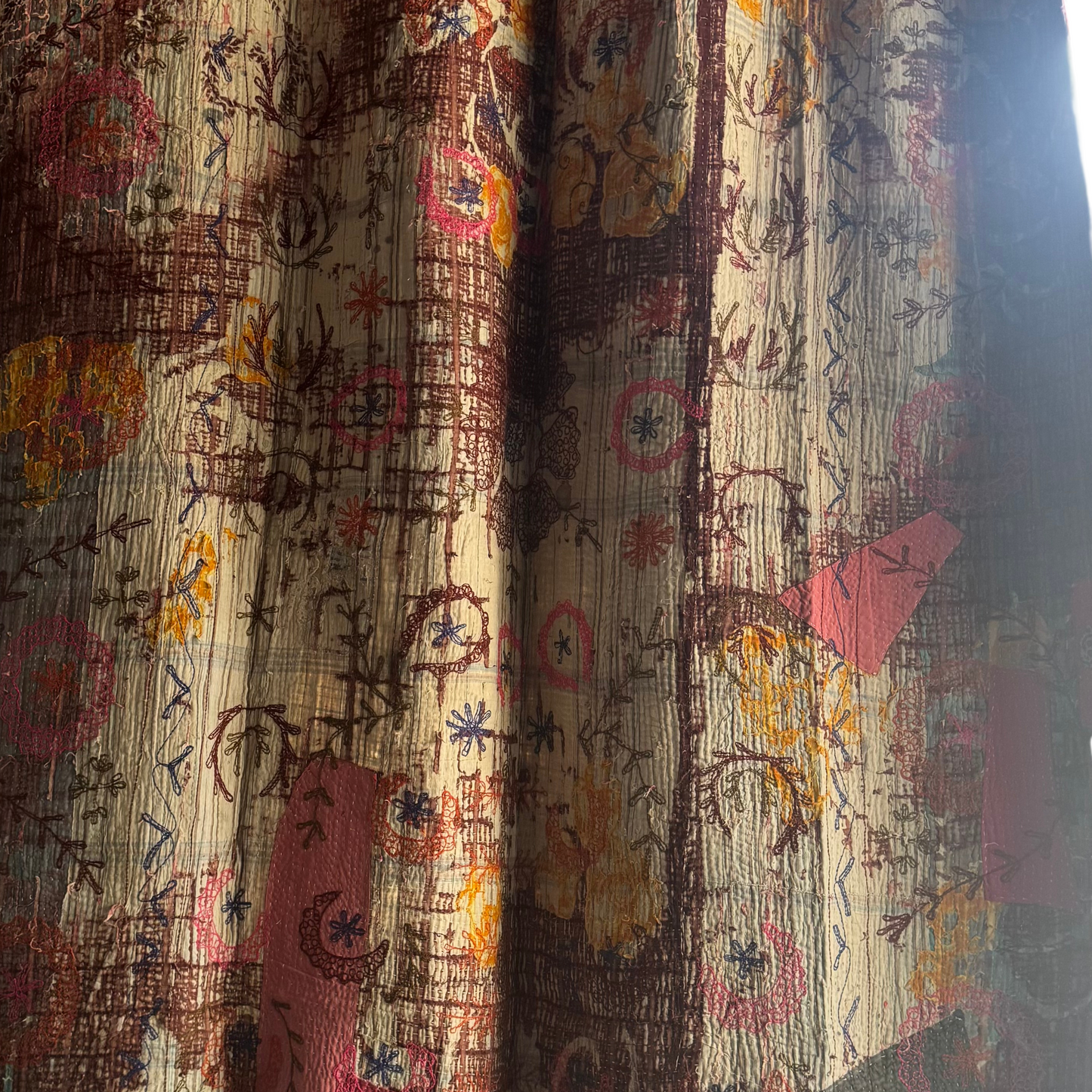 Macro of blue and brown floral stitches on the reverse side’s lightweight cotton