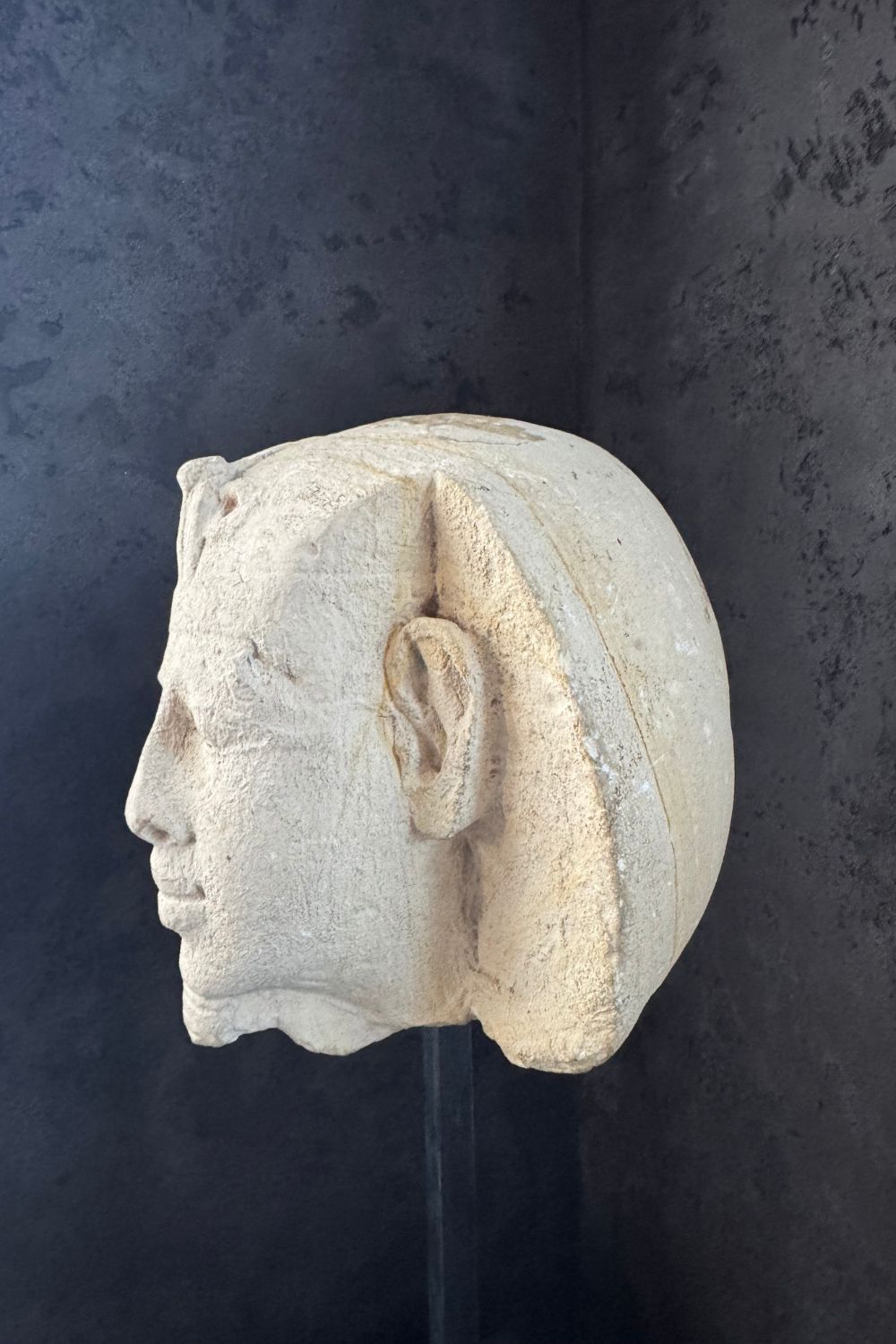 Side profile of the stone pharaoh head sculpture, showcasing the intricacy of the headdress.