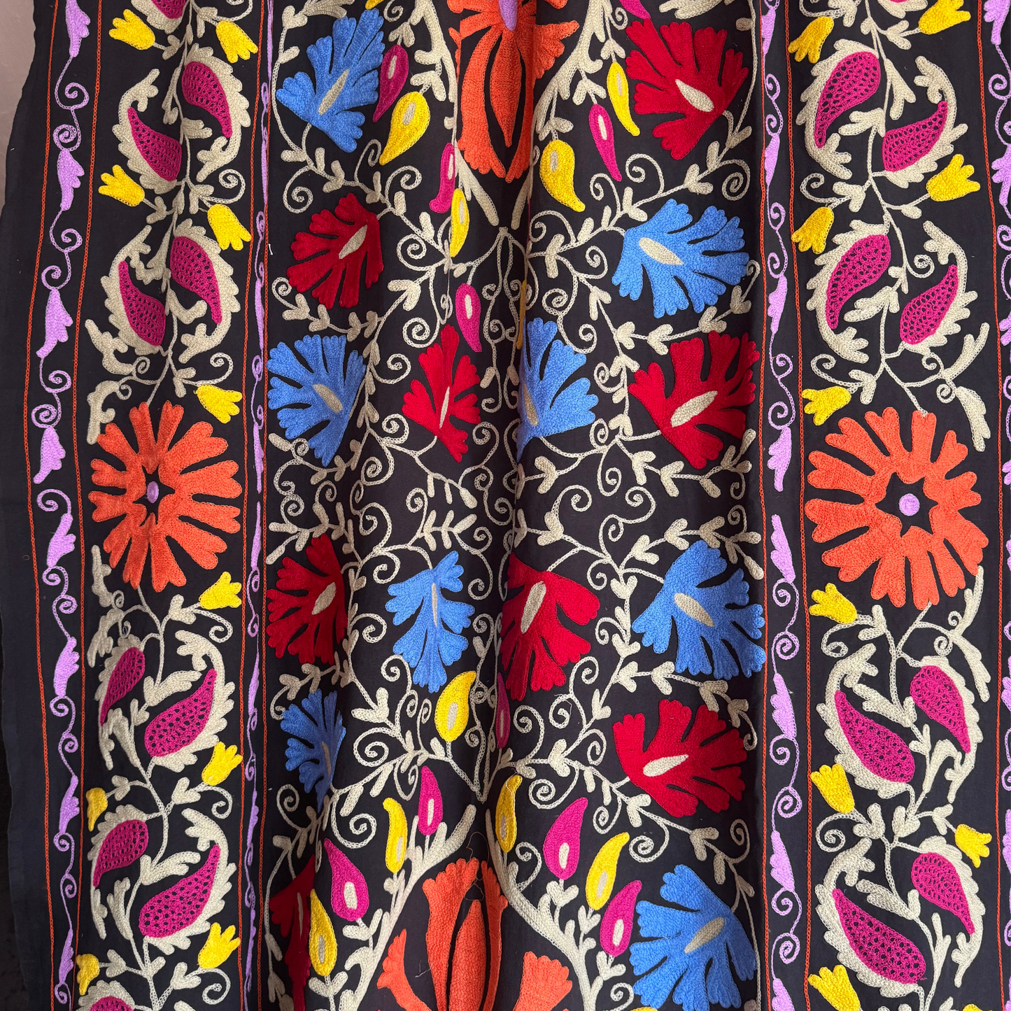 Cobalt-blue and light-green leaf motifs with red accents on black cotton