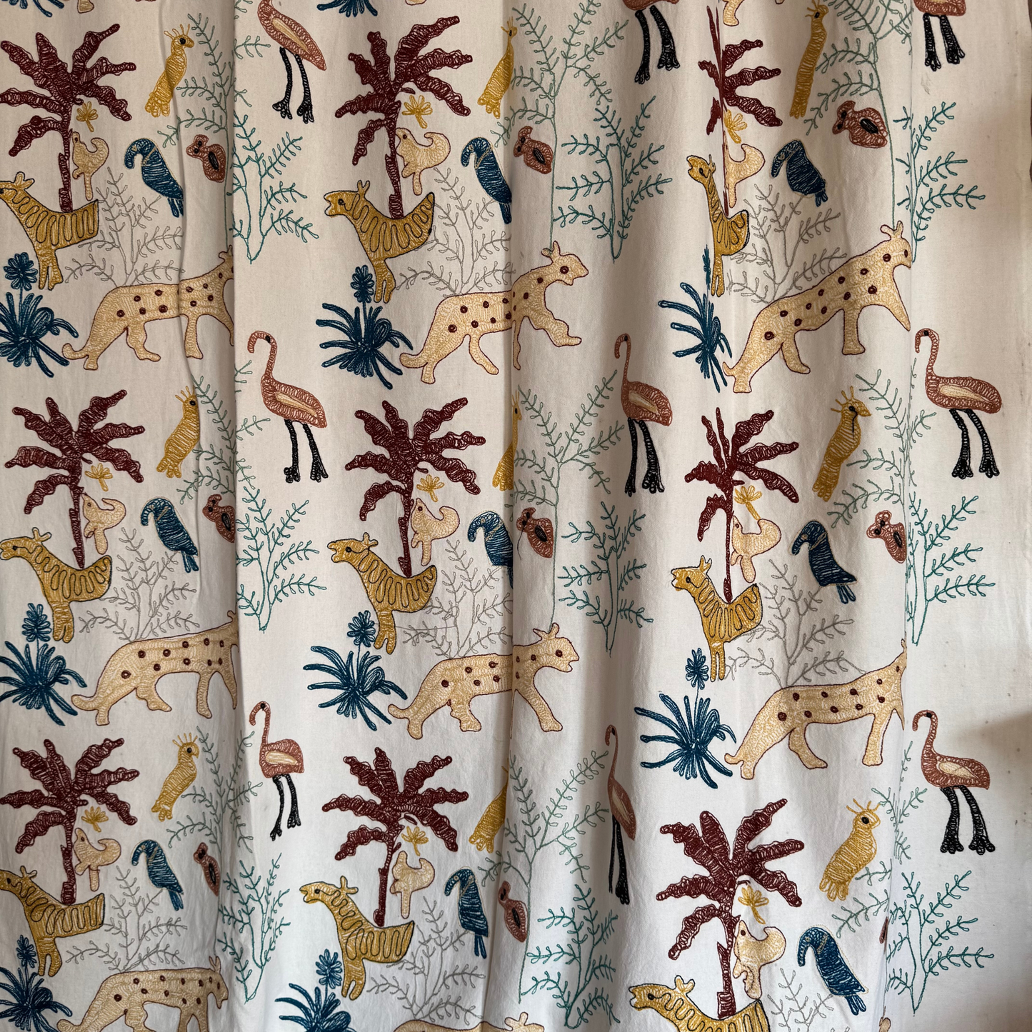 Edge of textile with black accent stitches and patterned border