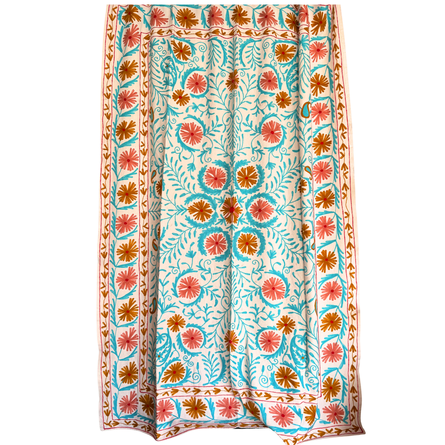Close-up of ocean-blue vine scroll embroidery and deep red flower accents on white ground