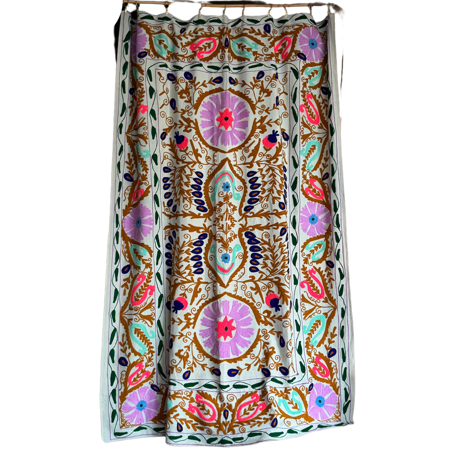 Full view of hand-embroidered Suzani on light green cotton with pink, turquoise, and ochre floral motifs