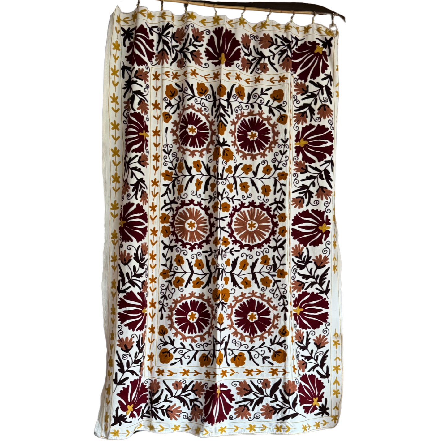 Full view of embroidered Suzani textile in maroon, gold, and ivory tones