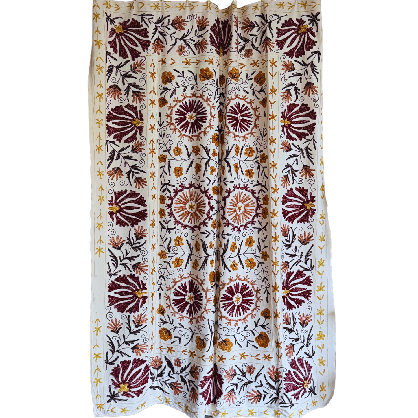 Suzani used as decorative wall textile with repeating floral motifs