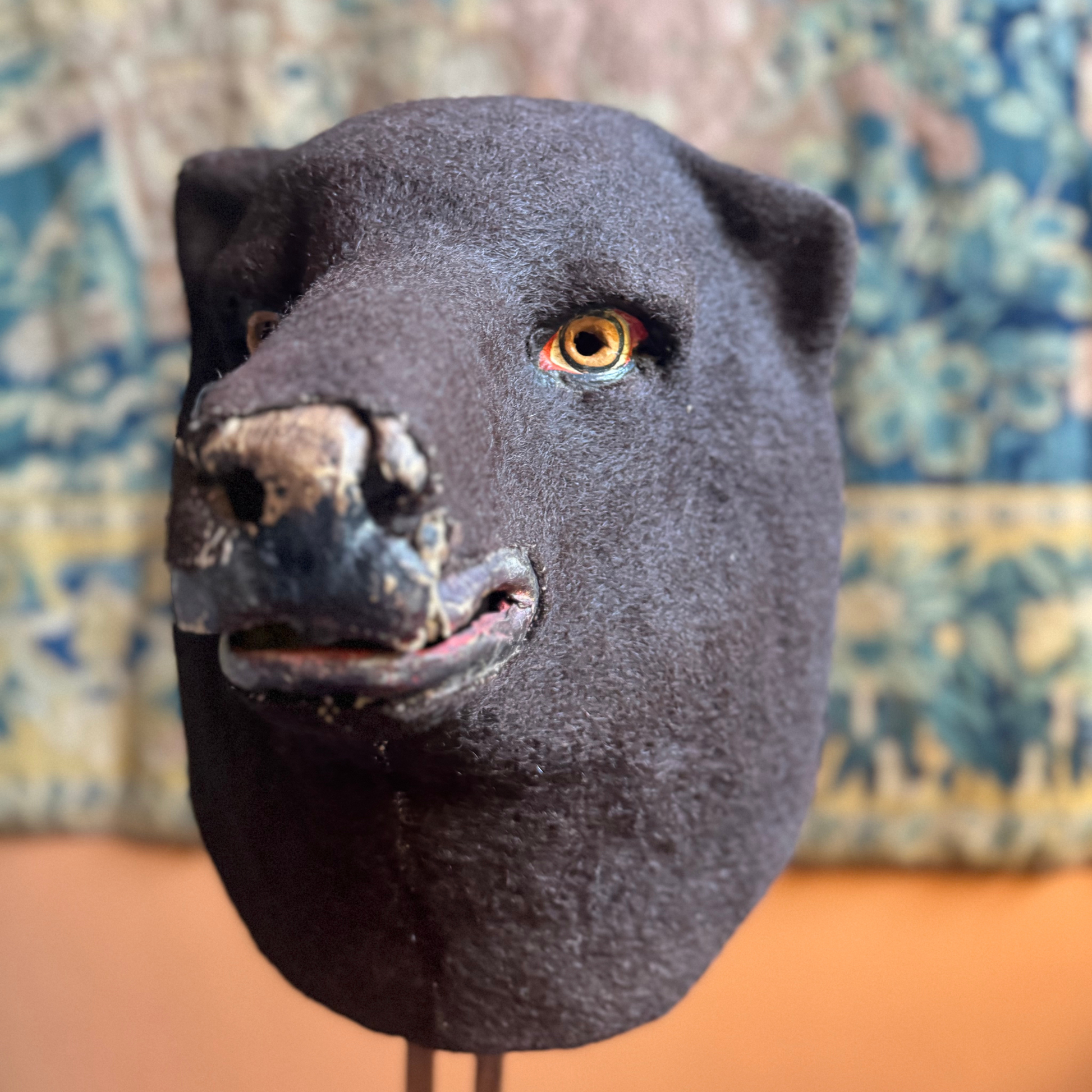 Front view of papier-mâché bear headpiece covered in felt with hand-painted eyes