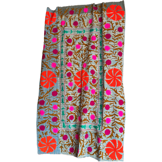 Full front view of checked ground with orange, fuchsia, ochre and green floral embroidery