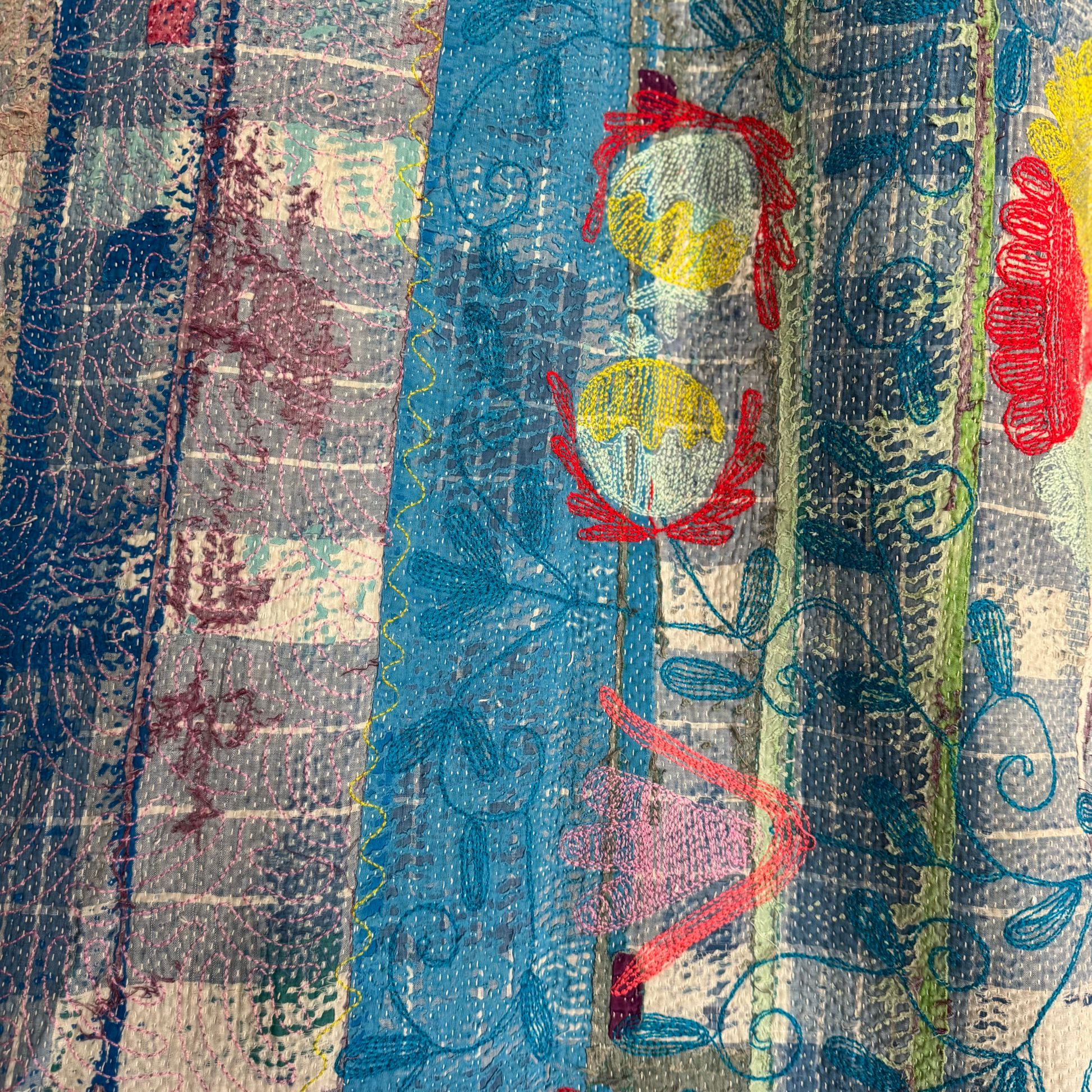 Close-up of wave-stitch accents and sari patchwork on reverse of cotton Kantha quilt throw