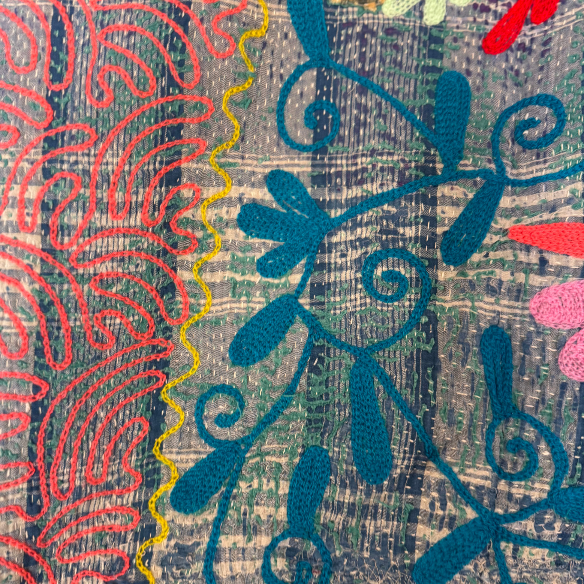 Close-up of coral-pink tulip embroidery and teal vine stitchwork on cotton Kantha quilt throw