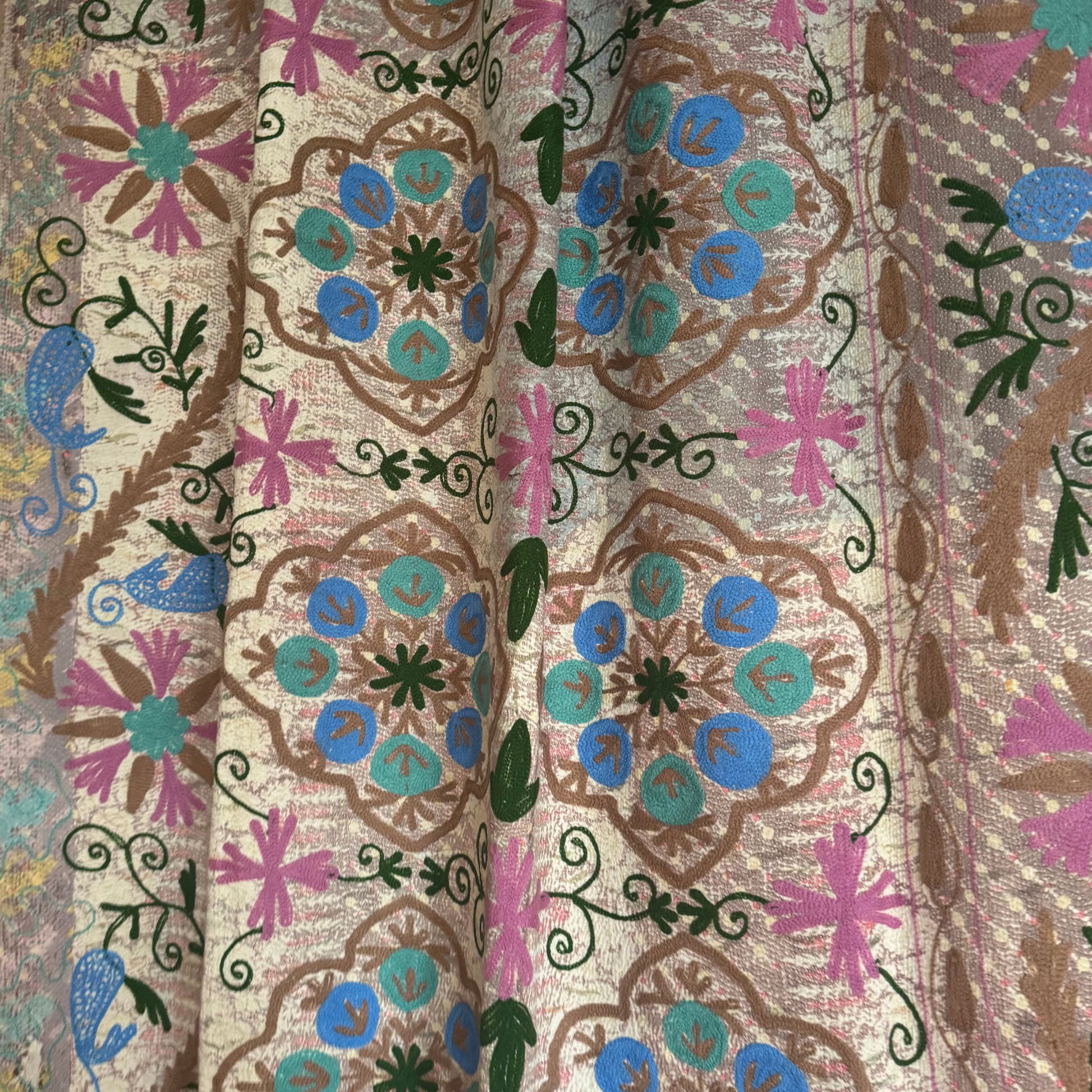 Detail showing painterly pastel pink, buttery yellow, and soft grey washes on repurposed sari cotton with running stitches