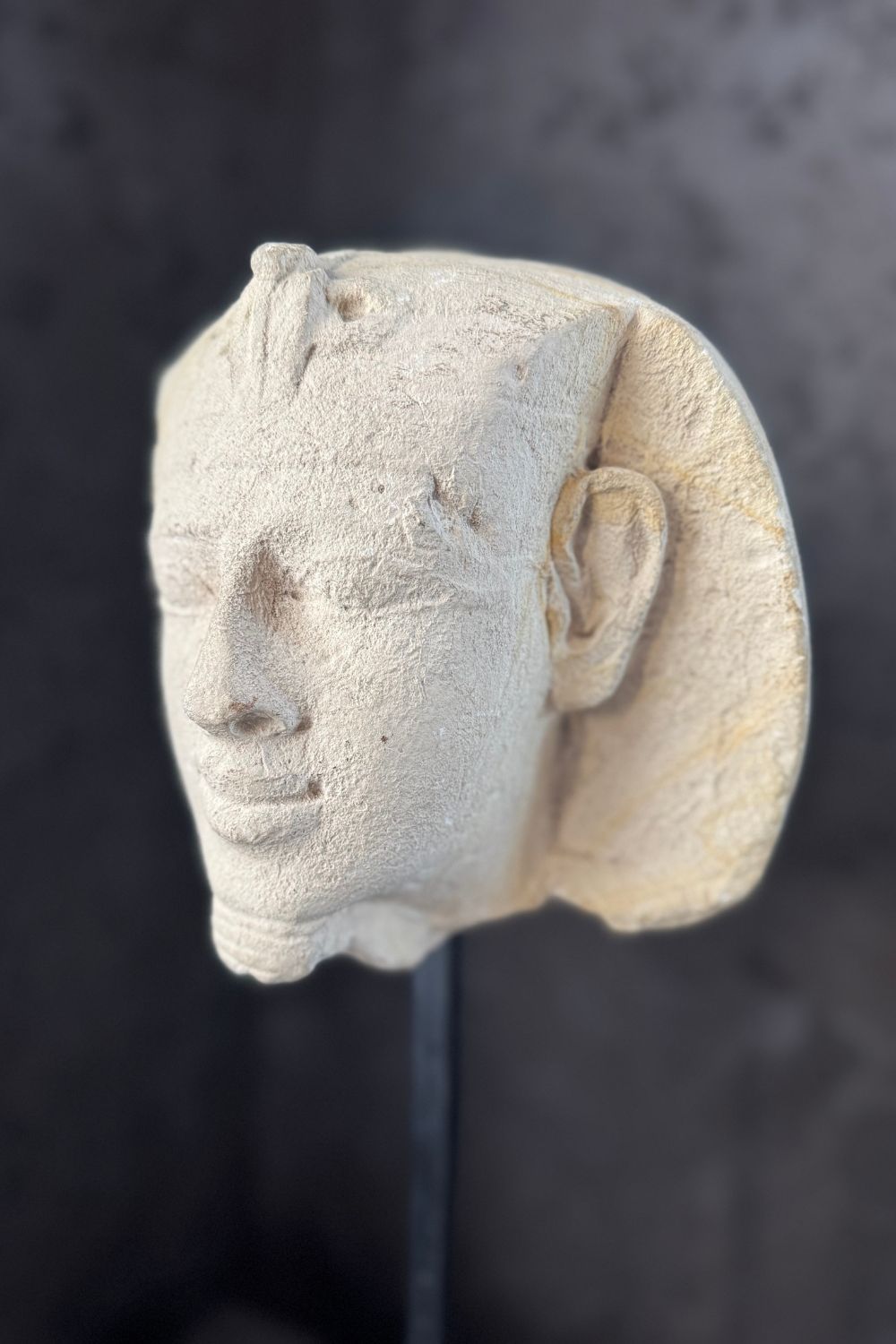 Base view of the stone pharaoh head sculpture, showing the sleek black stand supporting the sculpture.