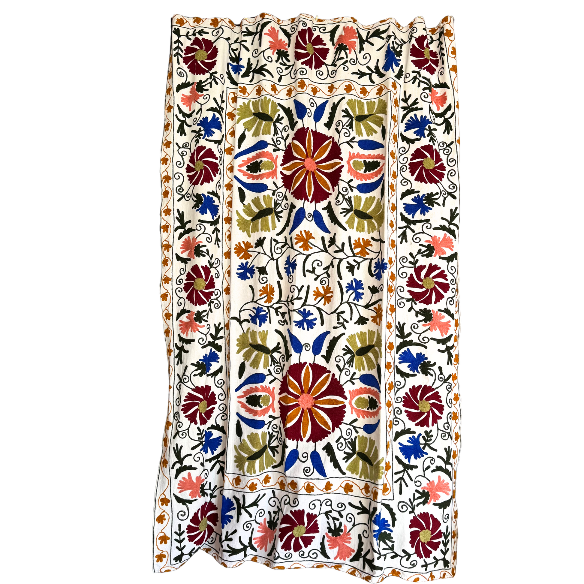 Close-up of embroidered burgundy and ochre floral motif on white Suzani background