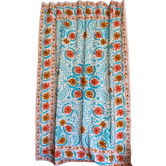 Front view of white cotton suzani with rose and gold-ochre floral medallions and ocean-blue vines